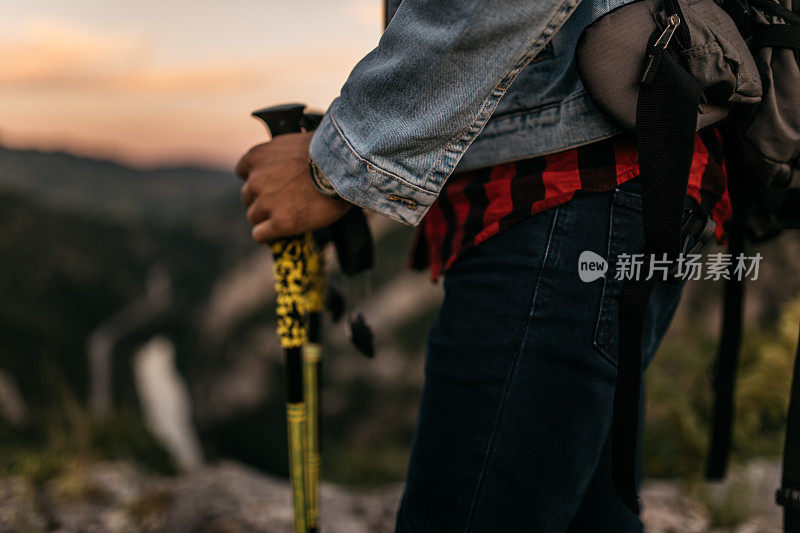 在山上拿着登山杖的徒步旅行者