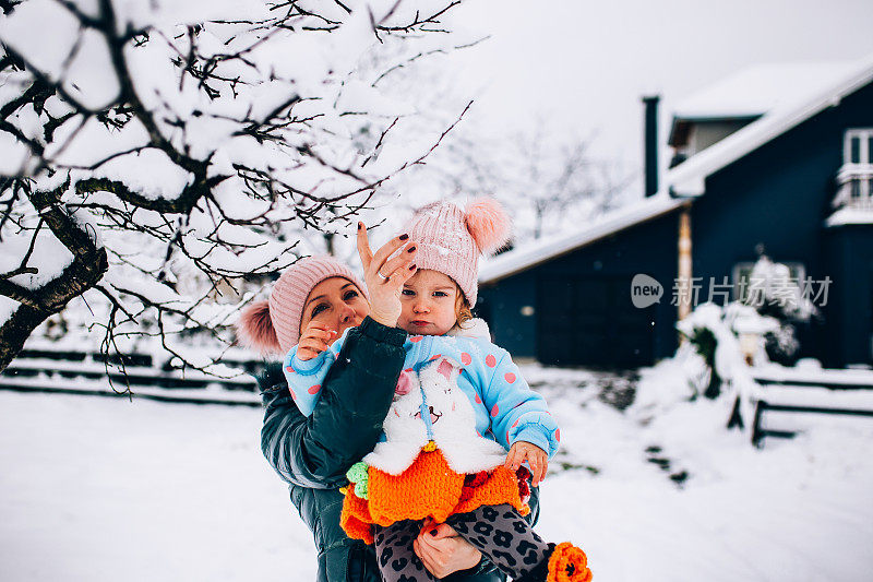 快乐的妈妈喜欢和她的孩子在雪地里玩