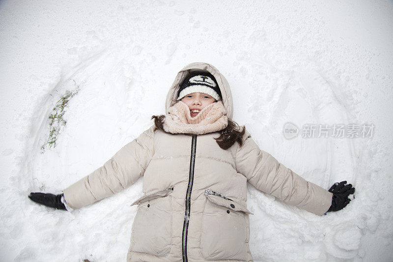 女孩躺在雪地里的地上