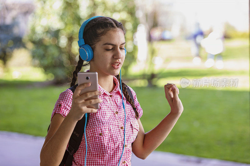 少女走在街上听着音乐