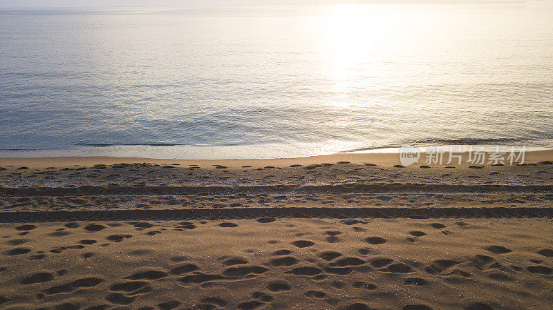在海滩上拍摄美丽的夏日日落。在海上日落。无人机镜头鸟瞰图