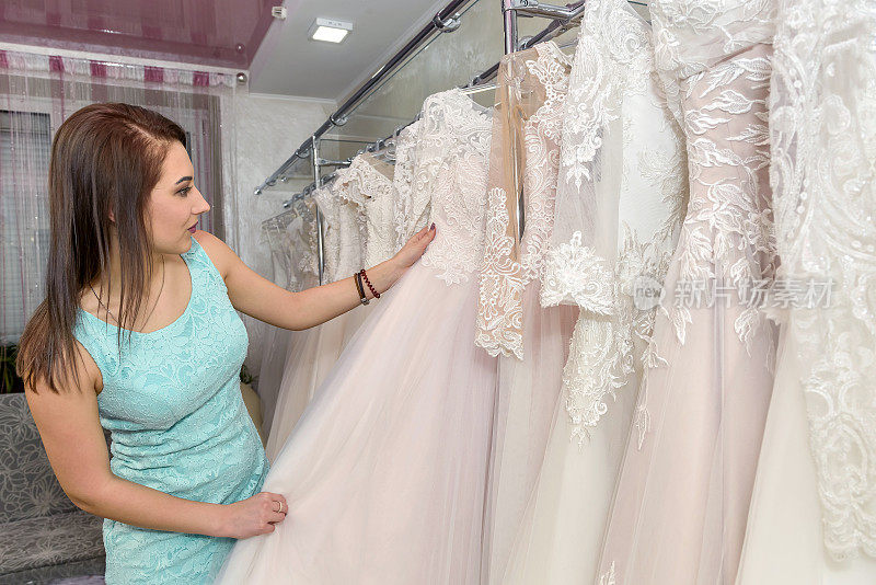 女人在新娘商店选择白色婚纱