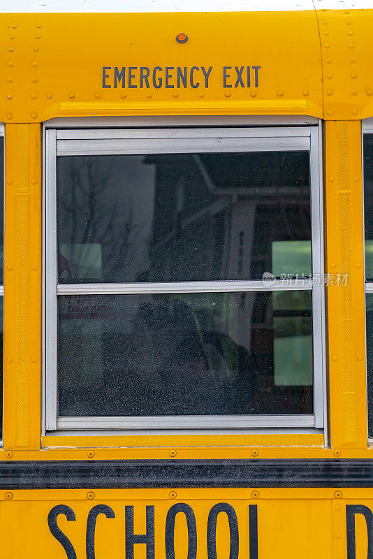 一辆黄色校车的外观，近距离观察它的玻璃窗