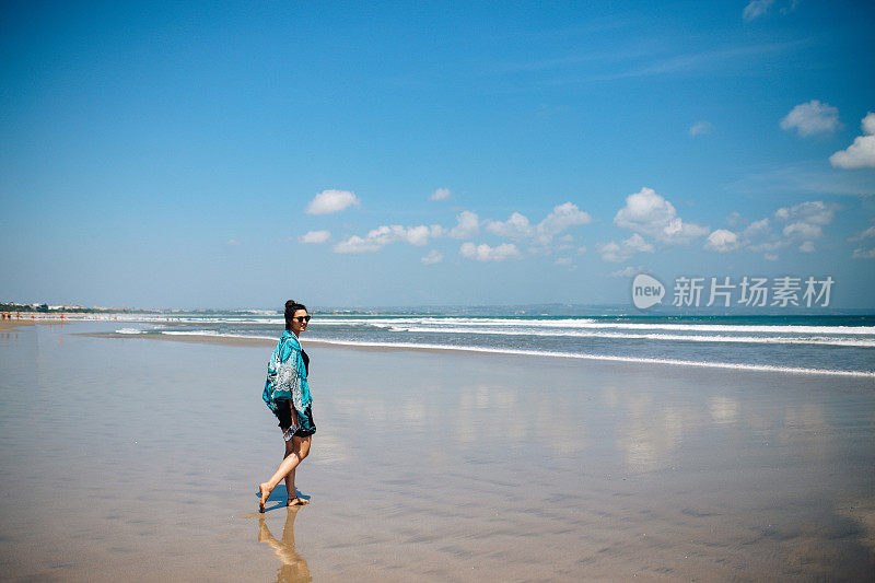 女游客喜欢在巴厘岛的海滩上散步