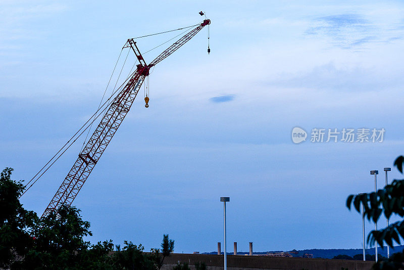 建筑顶部的施工起重机。下午轮廓