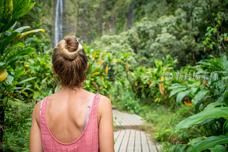 年轻女子在热带雨林中漫步，探索大自然