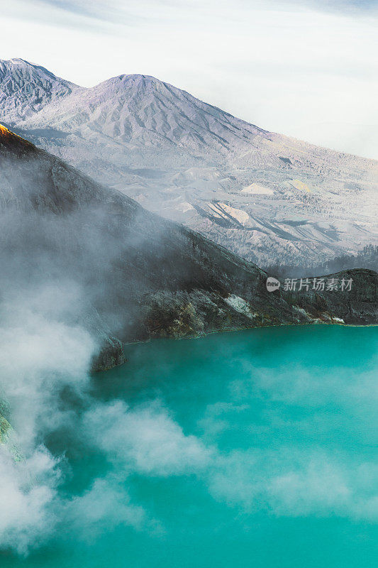 印度尼西亚东爪哇的伊真火山火山口的绿松石色湖泊，山脉和硫磺蒸汽的戏剧性景色