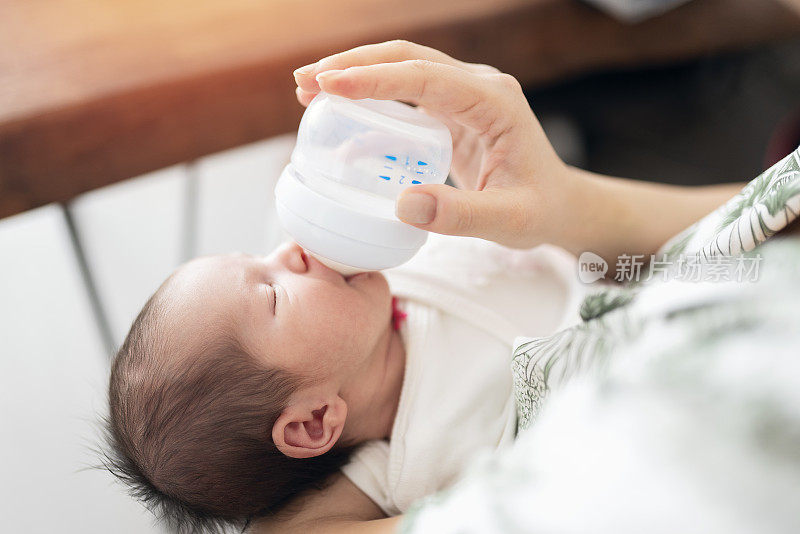 婴儿从奶瓶里喝牛奶
