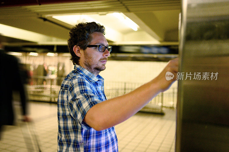 游客在看带有地铁时刻表的数字信息标牌