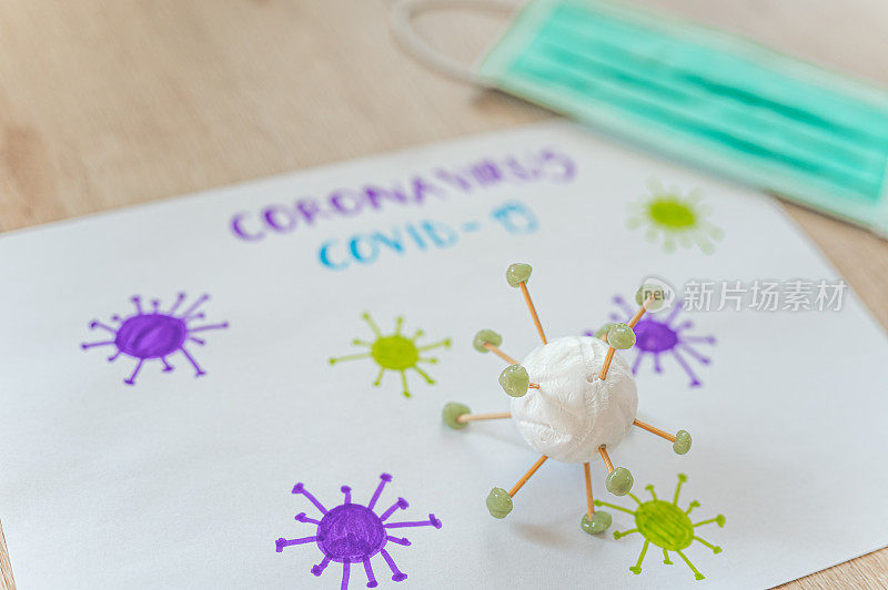 桌上有Covid-19冠状病毒和防护口罩的插图和模型包