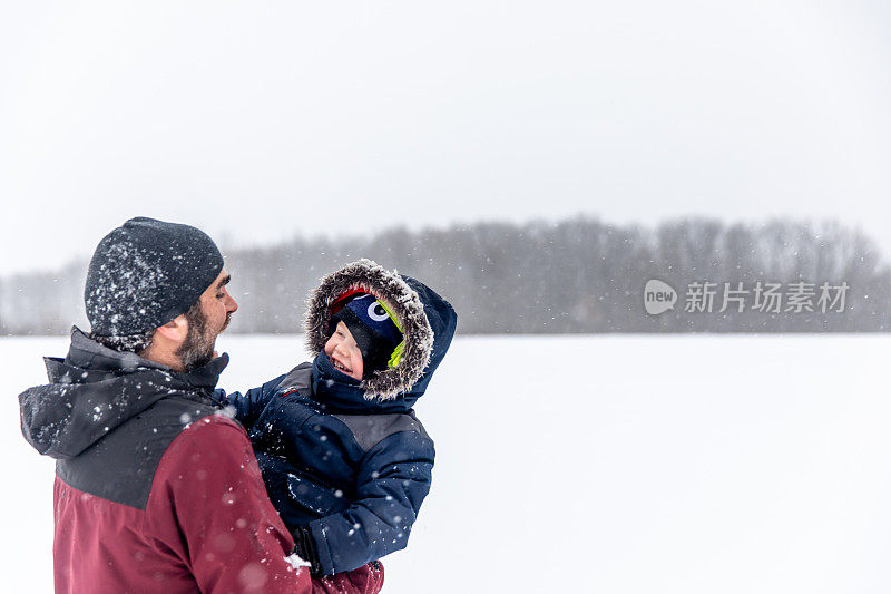 父亲和儿子在户外玩暴风雪