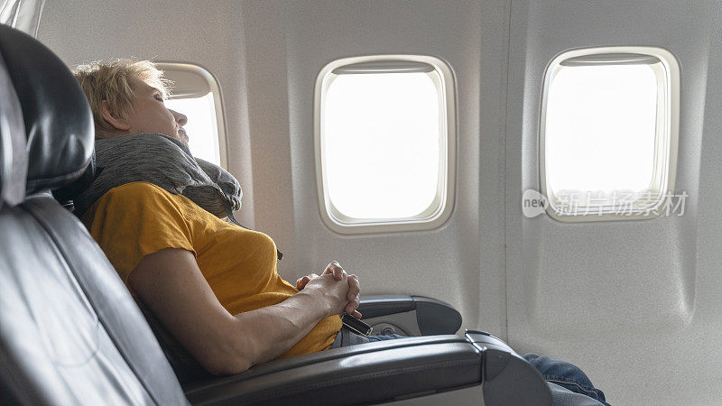 55岁的成年女性，在飞机上休息。