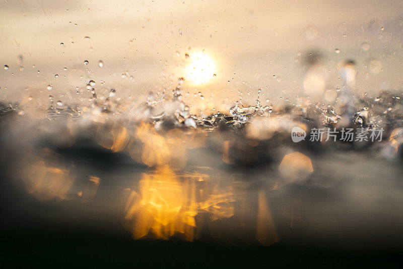 随着日出，雨点落在海面上