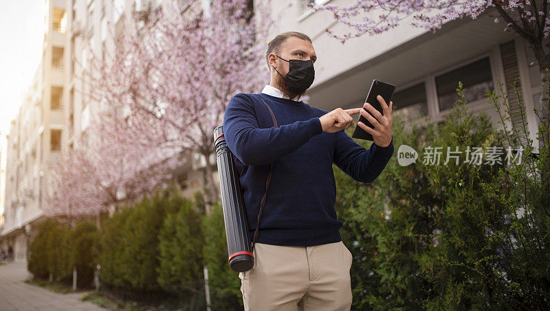 商人戴着口罩和智能手机去工作库存照片