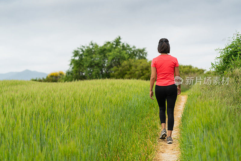 一名女子在封锁后走过绿色田野