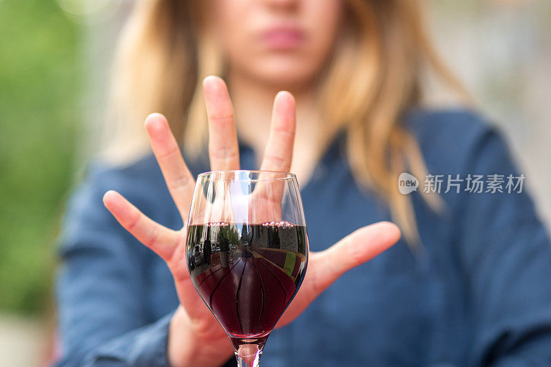 用手势拒绝喝葡萄酒或酒精饮料的女性。