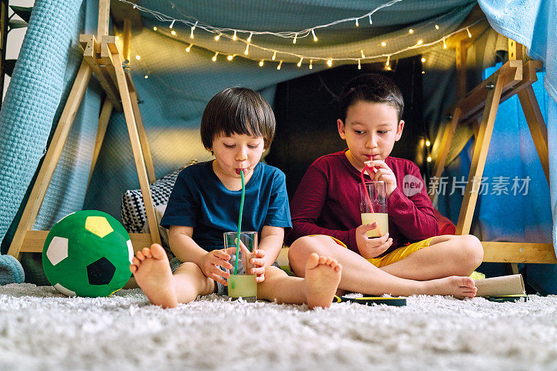 两个可爱的孩子在家里搭帐篷，一起玩耍