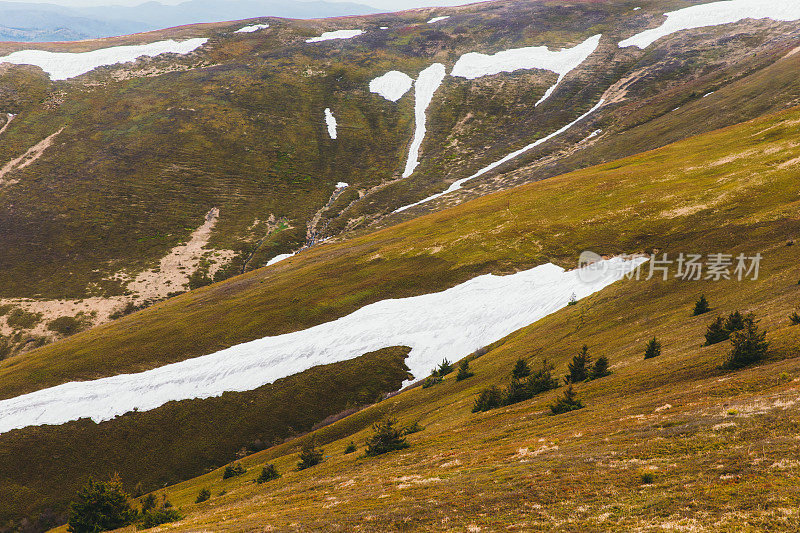 在明媚的春天，五颜六色的山峰被白雪覆盖