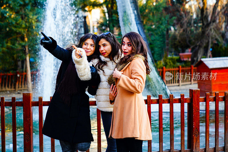 户外拍摄的三个年轻女人在城市街道上玩。多民族女性朋友享受在城市的一天。