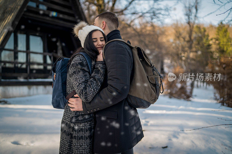 这对快乐的情侣在雪山徒步旅行时微笑着用手机自拍