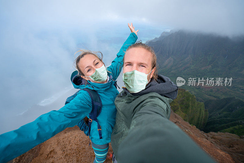 一对情侣在夏威夷徒步旅行，在山脊上自拍