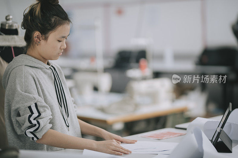 亚洲华裔女大学生在大学工作坊做服装项目