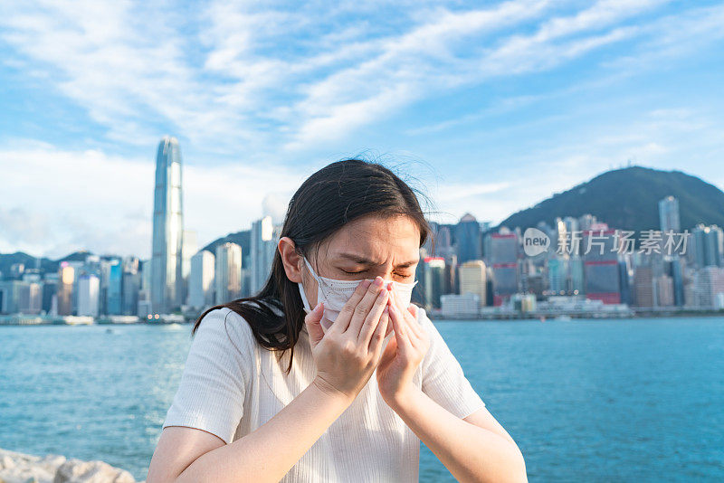 年轻的亚洲妇女戴着防护口罩，以防止冠状病毒的传播，全球卫生紧急疫情爆发