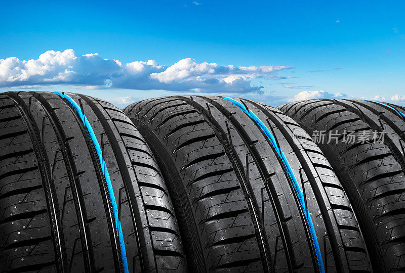 夏天的汽车轮胎在蓝天白云上行驶。轮胎堆栈的背景。汽车轮胎保护关闭。黑色的橡胶轮胎。全新的汽车轮胎。接近黑色轮胎轮廓。汽车轮胎排成一排