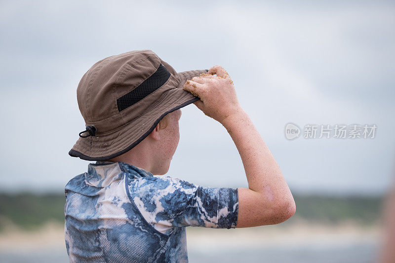 海滩上戴着太阳帽的小男孩