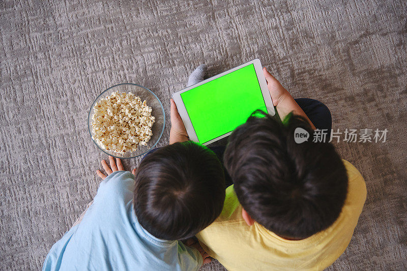 孩子们在家里一起使用电子平板电脑和看电影
