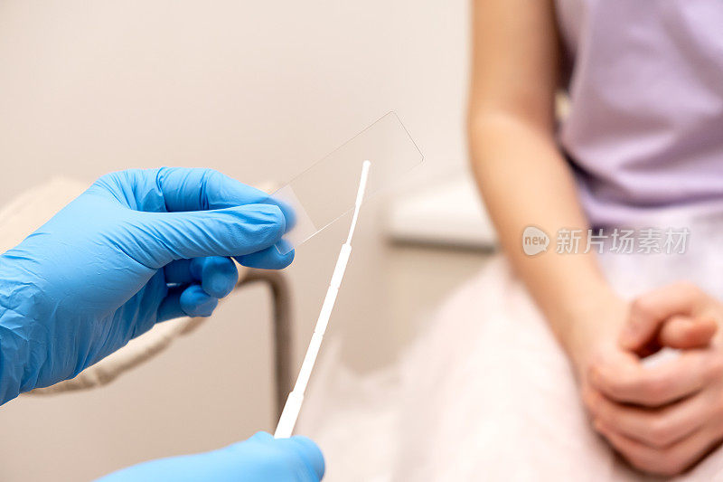 妇科医生将涂片放在显微镜切片上，用手特写。泌尿生殖系统疾病的诊断女性的健康，医学观念。
