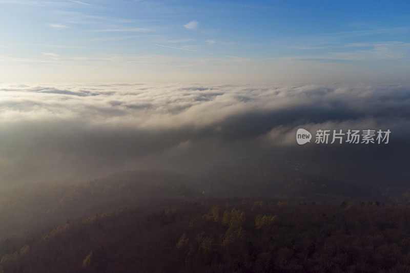 雾和阳光在秋天森林地区-陶诺斯山。鸟瞰图