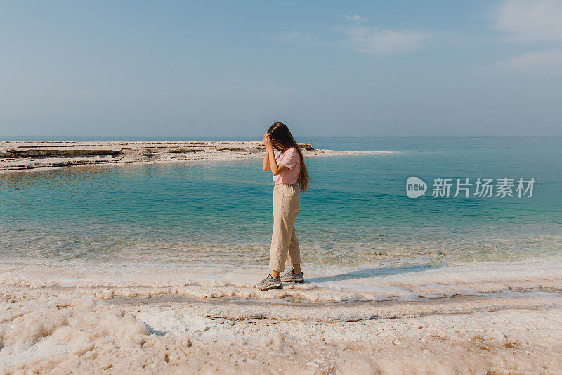 女性旅行者探索约旦死海的蓝绿色海水