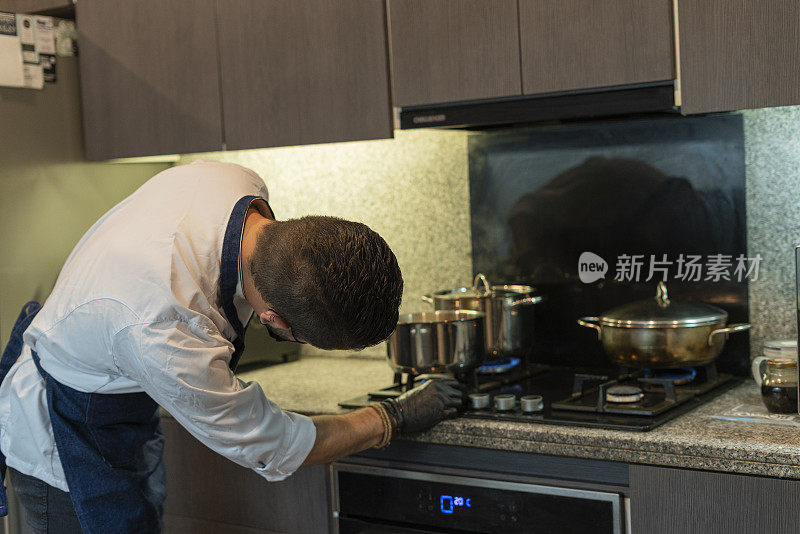 拉丁职业厨师被雇佣在他的客人的家里准备美味的菜肴在疫情期间