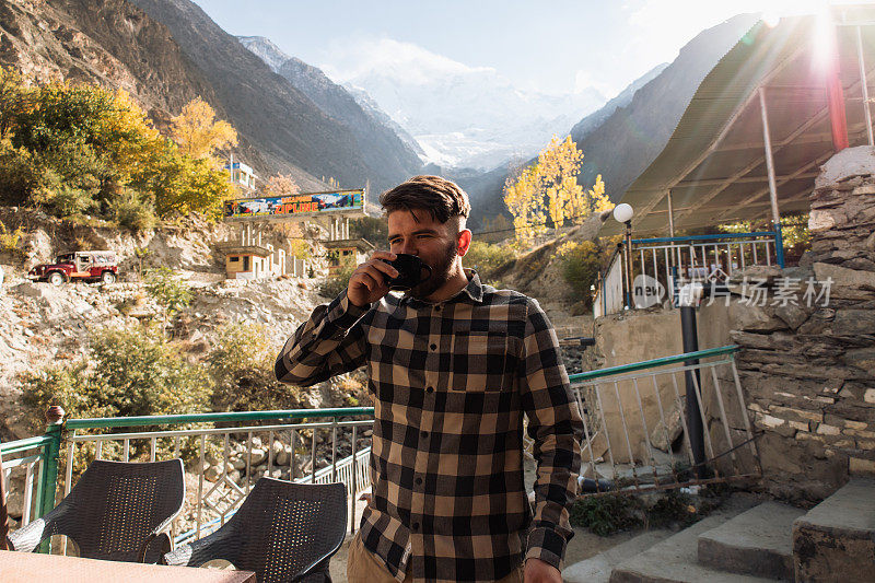 巴基斯坦，一个年轻人在Rakaposhi山边喝茶