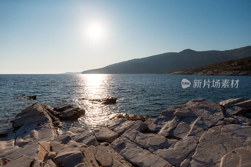 美丽的景色从岩石海岸上的海景与阳光反射在一个晴朗的日子