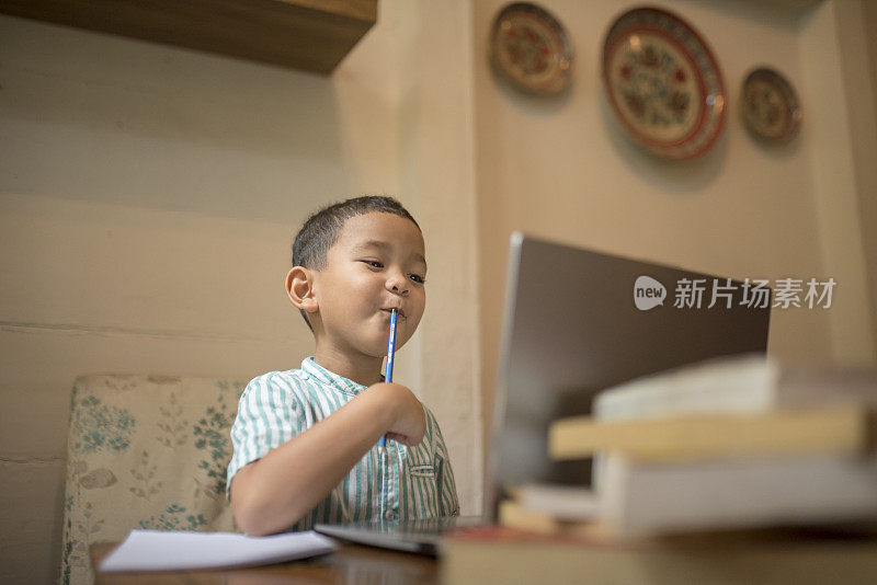 这个孩子正认真地用笔记本电脑学习