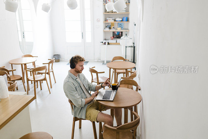 生姜商人使用笔记本电脑，在咖啡店进行视频通话