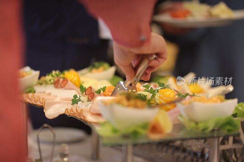 一位女士在自助餐厅挑选食物