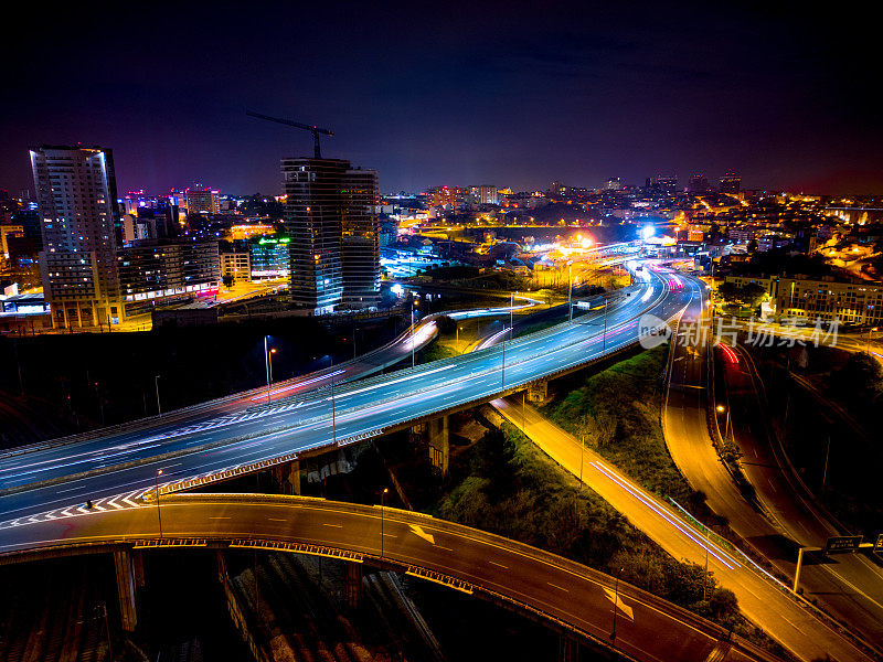 空中无人机的天空视图拍摄的交通在里斯本在夜间与五颜六色的光轨迹