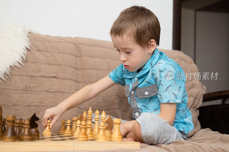 可爱的白人小男孩在家里下棋。小男孩与朋友、姐妹、兄弟一起玩棋盘游戏，积极发展国际象棋策略。早期发展和额外教育。