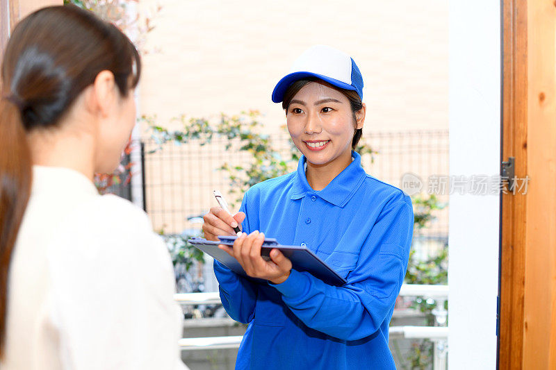 一名年轻的亚洲女性在入口处与一名女员工交谈时，表情令人不安。