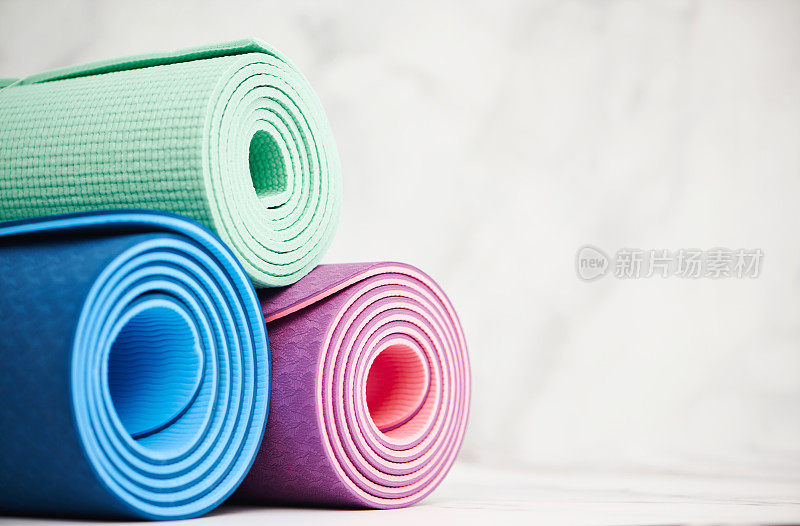 三个瑜伽垫或运动垫卷起来，留出空间供抄写。健康的生活方式
