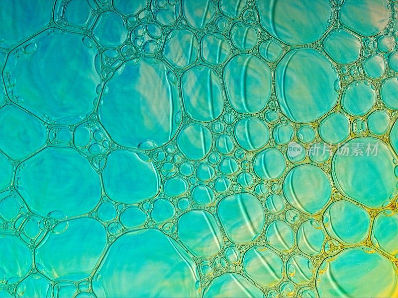 绿松石和金色的彩色泡沫微距摄影抽象从下面点燃