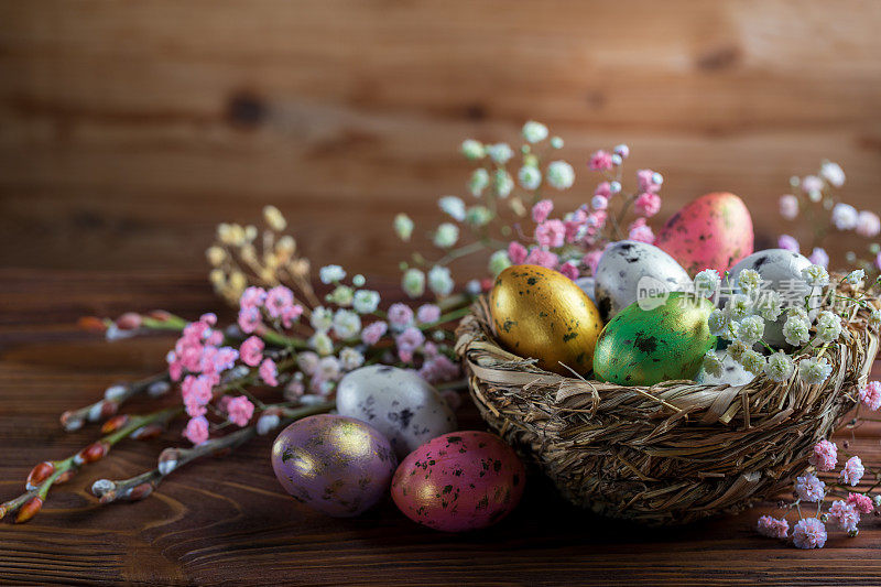 复活节背景或木制背景上绘有鸟窝彩蛋的贺卡。