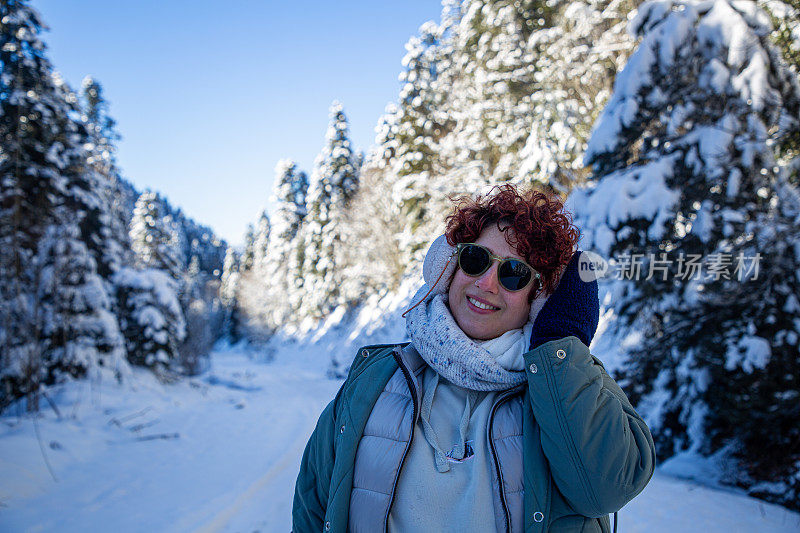 美丽的女人和冬天被雪覆盖的树