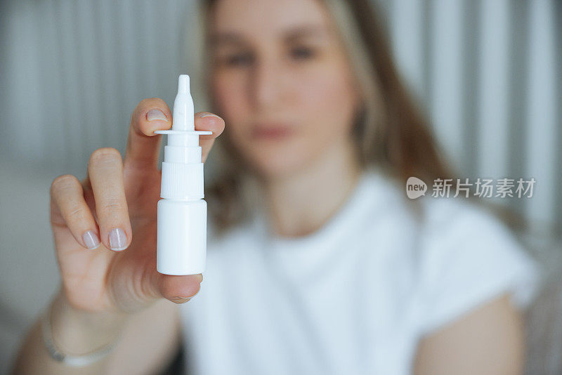 生病的年轻女子使用鼻腔喷雾剂