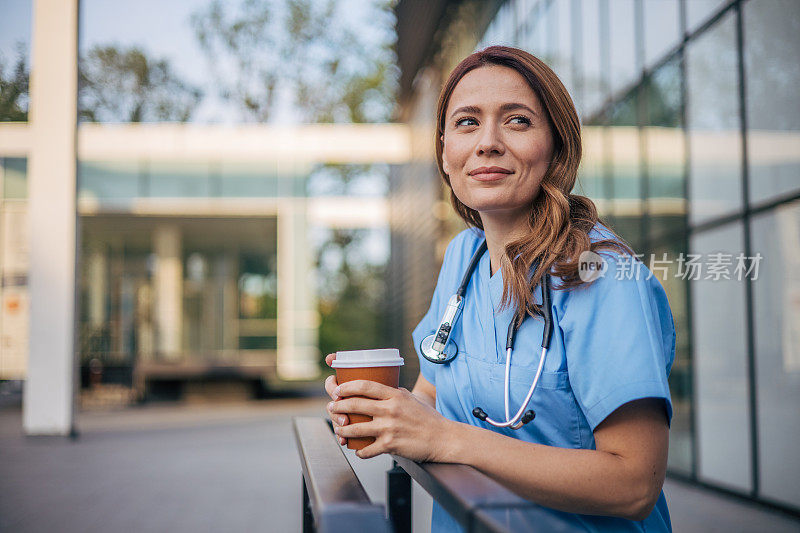 穿着制服的年轻成年护士在诊所喝咖啡休息