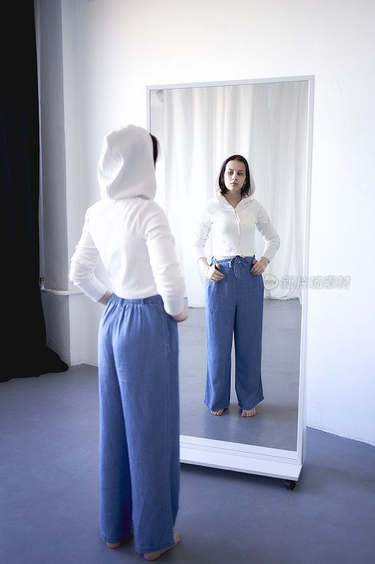 与脑癌作斗争的少女看着镜子中的自己，这是对来生的隐喻