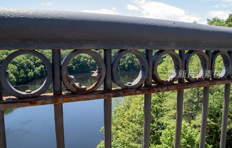 在一个阳光明媚的夏日，新英格兰桥上锈迹斑斑的护栏。